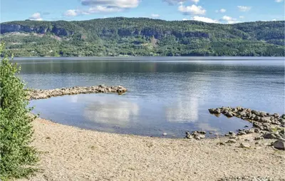 a large body of water with a rocky shore at Bergheim in Vikersund