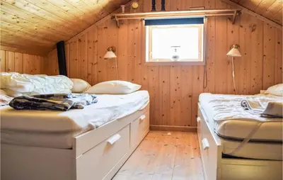 two beds in a room with wooden walls at Sjusjøvegen 1892 in Sjusjøen