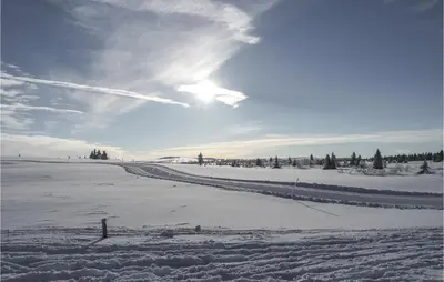 a snow covered field with the sun in the sky at Sjusjøvegen 1892 in Sjusjøen
