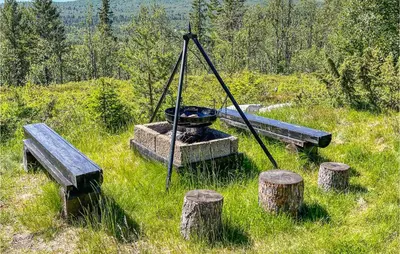 a swing in a field with some logs at Nice Home In Vinstra With Kitchen in Vinstra