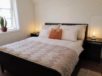 a bedroom with a bed with pillows and a window at Trygheim feriehus in Bud