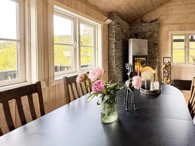a dining room table with a vase of flowers on it at 10 person holiday home in veggli-By Traum in Veggli