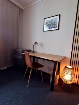 a desk in a room with a chair and a lamp at A11 Apartments in Ålesund