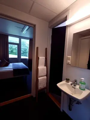 a bathroom with a sink and a window and a bed at A11 Apartments in Ålesund