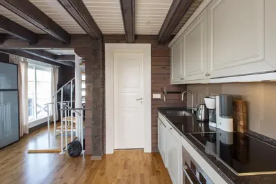 a kitchen with white cabinets and black counter tops at Mosetertoppen Panorama anneks 1B in Hafjell