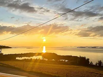 a sunset over a body of water with the sun setting at 6 person holiday home in MIDSUND-By Traum in Aukra