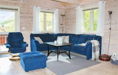 a living room with a blue couch and a table at 4 Bedroom Nice Home In Sogndal in Sogndal