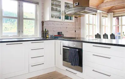 a kitchen with white cabinets and a stove at 4 Bedroom Nice Home In Sogndal in Sogndal