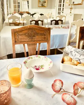 a table with a plate of eggs and a bowl of bread at VILLA HASSELBAKKEN in Eidsvoll