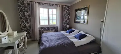 a bedroom with a bed with blue pillows and a window at VILLA HASSELBAKKEN in Eidsvoll