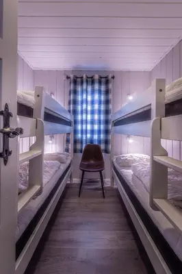 a room with two bunk beds and a chair at Beito Resort Hytter in Beitostøl