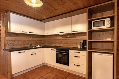a kitchen with white cabinets and a microwave at Beito Resort Hytter in Beitostøl