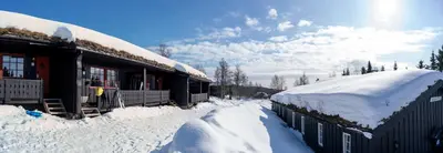 a train station covered in snow next to a building at Beito Resort Hytter in Beitostøl