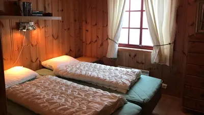 two beds sitting in a room with a window at Berghstua - Natrudstilen på Sjusjøen in Sjusjøen