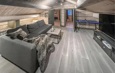 a living room with a couch and a tv at Cozy Home In Sjusjøen With Sauna in Sjusjøen