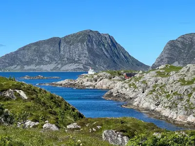 a body of water with a mountain in the background at Torvholmen in Fosnavåg