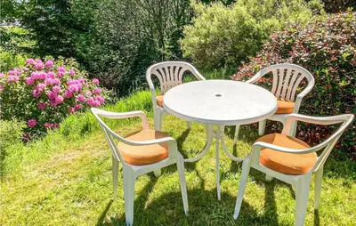 a white table and two chairs with a table and flowers at 3 Bedroom Awesome Home In Leikanger in Leikanger