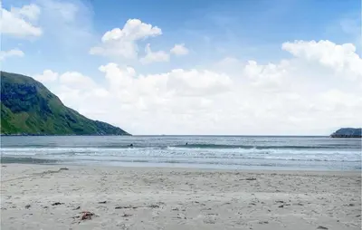 a beach with people swimming in the ocean at 3 Bedroom Awesome Home In Leikanger in Leikanger