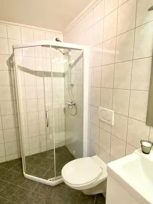 a bathroom with a shower and a toilet and a sink at Apartment «Ladegården» in Bergen in Bergen