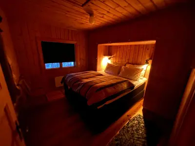 a bedroom with a bed in a wooden room at Kultan in Åmotsdal