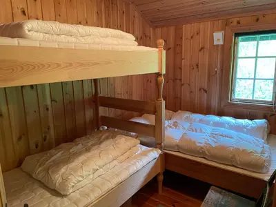 two bunk beds in a cabin with a window at Kultan in Åmotsdal