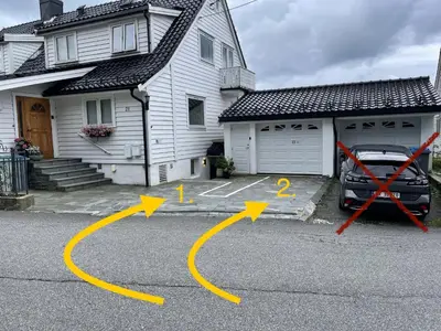 a car parked in a parking lot in front of a house at Floien City House -free parking in Bergen