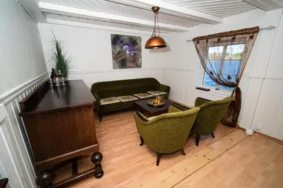a living room with a couch and a table and chairs at Drømmebrygga in Averoy