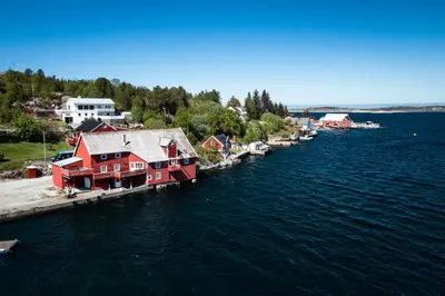 an aerial view of a harbor with red houses on the water at Drømmebrygga in Averoy