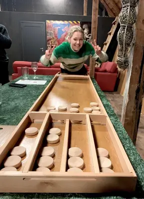 a woman is standing in front of a table with a game at Drømmebrygga in Averoy