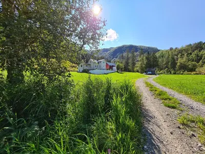 a dirt road leading to a house in a field at Jondal Nice apartment with bed linen incuded in Jondal