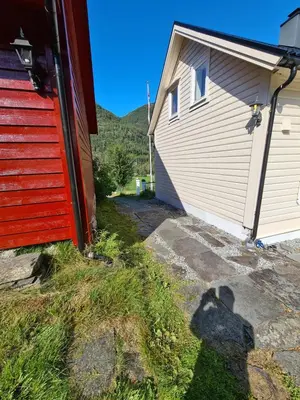a shadow of a person standing next to a building at Jondal Nice apartment with bed linen incuded in Jondal