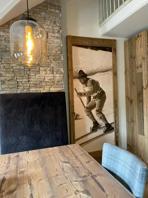 a man on a snowboard in a room with a mirror at Gjestegaarden Leiligheter in Beitostøl