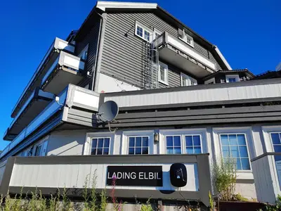 a large building with a sign in front of it at Gjestegaarden Leiligheter in Beitostøl