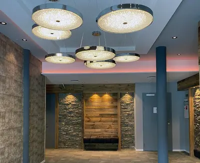 a lobby with several chandeliers hanging from the ceiling at Gjestegaarden Leiligheter in Beitostøl
