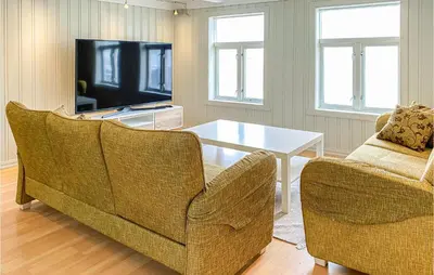 a living room with two chairs and a table and a tv at Cozy Home In Kristiansund With Wifi in Kristiansund