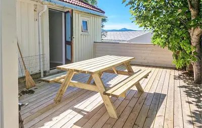 a wooden picnic table sitting on a wooden deck at Cozy Home In Kristiansund With Wifi in Kristiansund