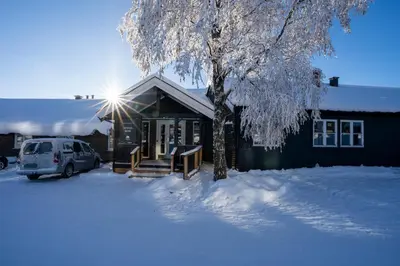 a house with a car parked in the snow at Bergo Rom in Beitostøl