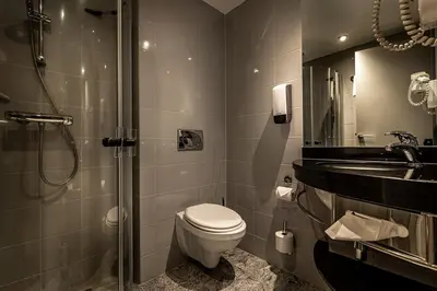 a bathroom with a toilet and a sink and a shower at Bergo Rom in Beitostøl