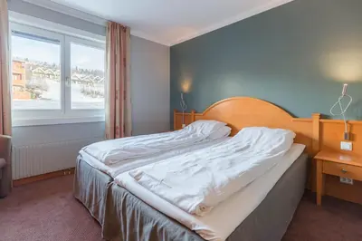 a bedroom with a bed and a window at Bergo Rom in Beitostøl