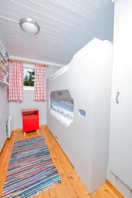 a room with a bunk bed in a house at Nærglimt - cabin by the lake Næra in Ringsaker