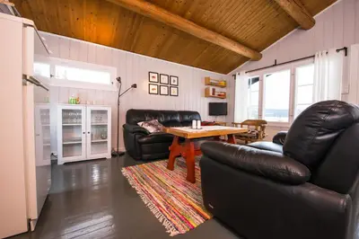 a living room with two leather chairs and a table at Nærglimt - cabin by the lake Næra in Ringsaker