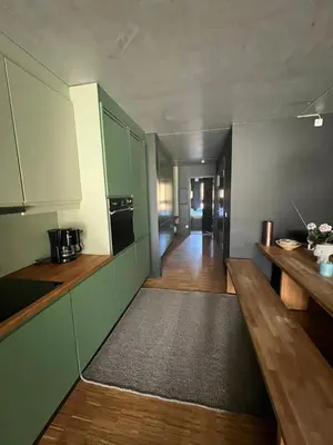 a kitchen with green cabinets and a wooden floor at Fin leilighet ca 30 min med bil til Hunderfossen in Favang