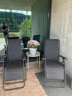 two chairs and a table with a vase of flowers at Fin leilighet ca 30 min med bil til Hunderfossen in Favang