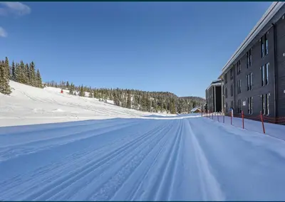 a snow covered street next to a building at Fin leilighet ca 30 min med bil til Hunderfossen in Favang