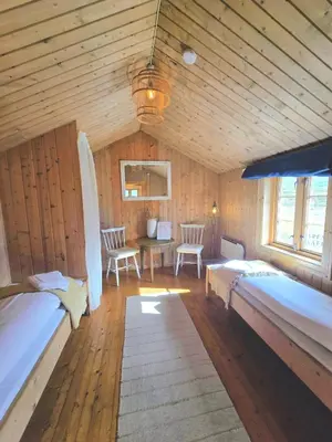 a bedroom with two beds and a table and chairs at Kyrkjestølen B&B in Tyinkrysset