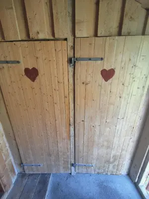 a pair of wooden doors in a barn with hearts on them at Kyrkjestølen B&B in Tyinkrysset