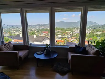 a living room with couches and a table in front of windows at Beautiful Villa with amazing view in Bergen. in Bergen