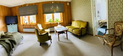 a living room with a couch and chairs and a table at Glomstad Gjestehus in Tretten