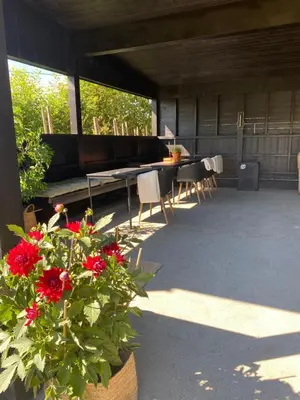 a patio with a table and chairs and red flowers at Glomstad Gjestehus in Tretten