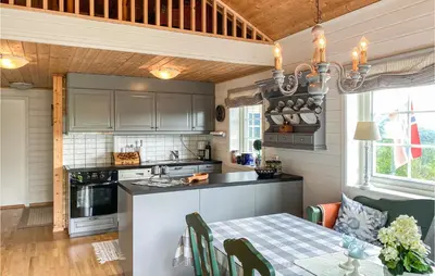 a kitchen and dining room with a table and a stove at Gorgeous Home In Øydegard in Nastad